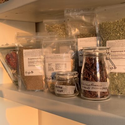a group of bagged and jarred herbs on a shelf